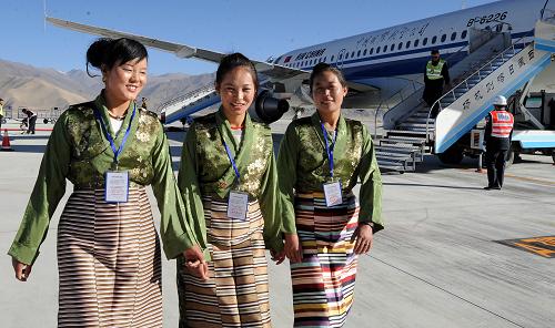 Three Tibetan women walks past a plane of Air China lands at Xigaze Airport in Xigaze, southwest China&apos;s Tibet Autonomous Region, on Oct. 30, 2010. Xigaze Airport opened Saturday, marking the launching of the fifth civil airport in Tibet.[Xinhua]