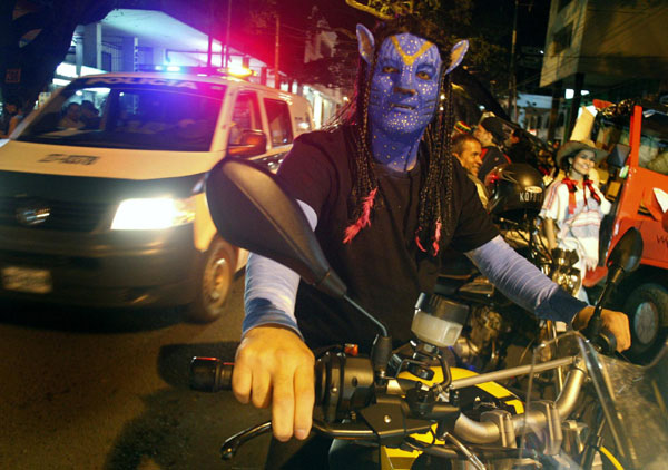 A man dressed as a character from the movie Avatar takes part in the &apos;Moto Halloween Party 2010&apos; in Cali, Oct 28, 2010. [China Daily/Agencies]