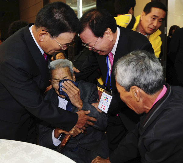 DPRK&apos;s Lee Jong-ryol (C, bottom) cries as he meets his ROK&apos;s younger brothers and son during inter-Korean temporary family reunions at Mount Kumgang resort in DPRK, Oct 30, 2010. [China Daily/Agencies]