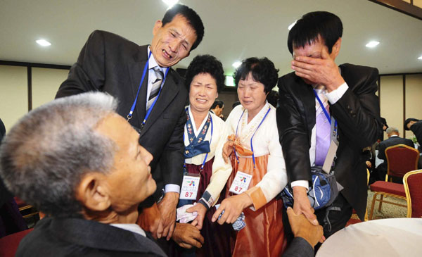 DPRK&apos;s Son Jong-taek (L) looks at his ROK&apos;s younger brothers and sisters during inter-Korean temporary family reunions at Mount Kumgang resort in DPRK, Oct 30, 2010. [China Daily/Agencies]