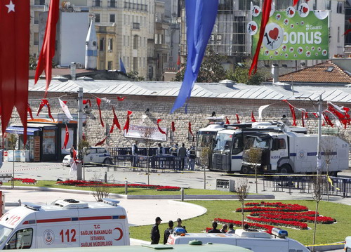 Rescue teams work at the scene of an explosion near the police vehicles in central Istanbul&apos;s Taksim Square October 31, 2010. The suspected suicide bomber targeting Turkish police wounded 22 people in the centre of Istanbul on Sunday.[China Daily/Agencies]