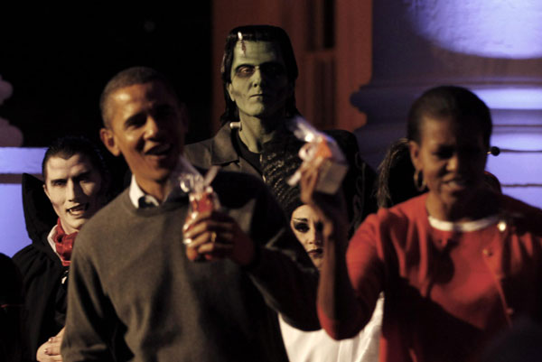 Actors dressed as Dracula (L) and Frankenstein (C) watch as US President Barack Obama and first lady Michelle Obama participate in a Halloween trick-or-treat on the steps of the North Portico of the White House in Washington, Oct 31, 2010. [China Daily/Agencies]