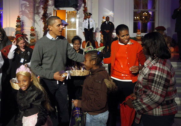 US President Barack Obama and first lady Michelle Obama participate in a Halloween trick-or-treat on the steps of the North Portico of the White House in Washington, Oct 31, 2010. [China Daily/Agencies]