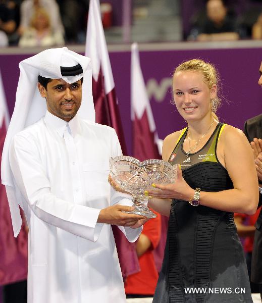 Caroline Wozniacki (R) of Denmark receives the trophy from Nasser al-khulaifi, head of the Qatar Tennis Federation, after the final match against Kim Clijsters of Belgium at the WTA Tour Championships in Doha, Qatar, Oct. 31, 2010. Wozniacki lost 1-2. (Xinhua/Chen Shaojin) 