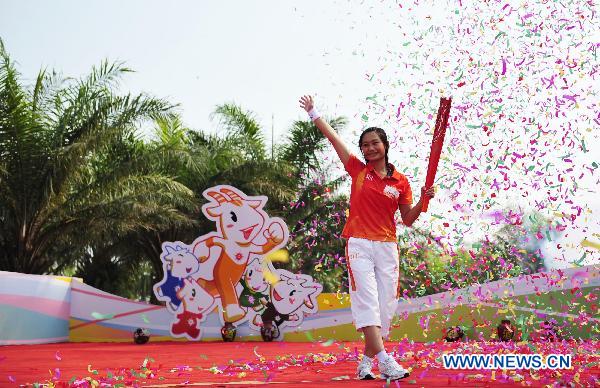 The 80th torchbearer Lao Lishi waves to the crowd at the end of the torch relay for the 16th Asian Games in Zhanjiang City, south China's Guangdong Province, Nov. 1, 2010. (Xinhua/Liang Xu) 