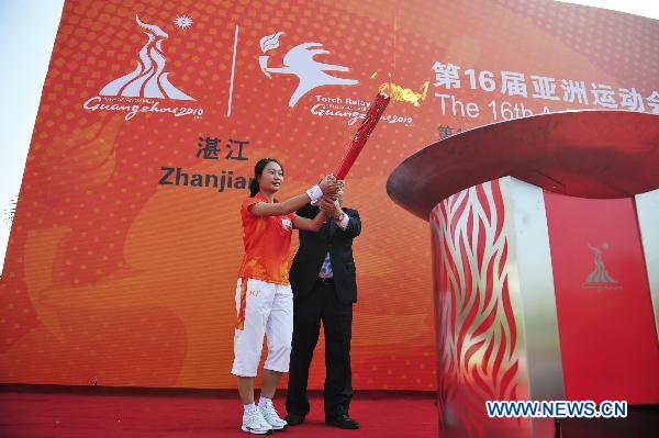 The 80th torchbearer Lao Lishi (L) and Chen Yaoguang, head of Zhanjiang municipal committee of the Communist Party of China, light the cauldron together at the end of the torch relay for the 16th Asian Games in Zhanjiang City, south China's Guangdong Province, Nov. 1, 2010. (Xinhua/Liang Xu) 