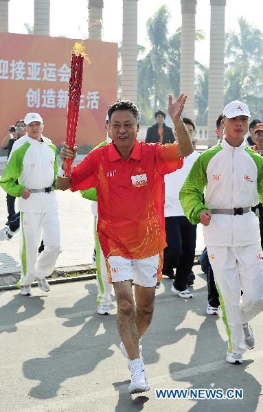 The second torchbearer Pan Nasheng runs with the torch during the torch relay for the 16th Asian Games in Zhanjiang City, south China's Guangdong Province, Nov. 1, 2010. (Xinhua/Liang Xu) 