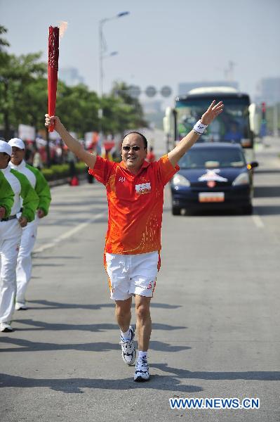 The 79th torchbearer Liang Zhipeng runs with the torch during the torch relay for the 16th Asian Games in Zhanjiang City, south China's Guangdong Province, Nov. 1, 2010. (Xinhua/Liang Xu) 