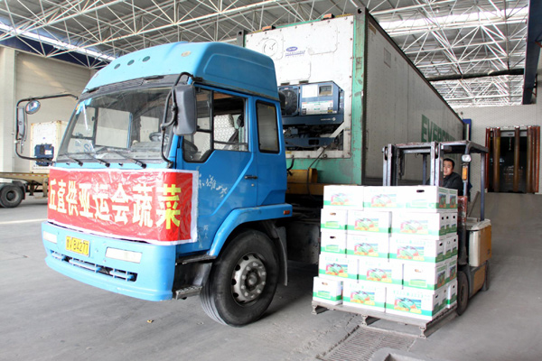 A worker in Anqiu, East China&apos;s Shandong province, loads boxes of vegetables onto a truck to be transported to Guangzhou, Nov 1, 2010. [Xinhua]