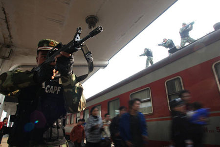 Armed soldiers protect passengers during an anti-terrorism drill for the Guangzhou Asian Games' smooth operation in Huaibei, East China's Anhui province on October 31, 2010. 