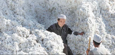 Workers process cotton in the Xinjiang Uygur autonomous region. Hikes in the prices of raw materials such as cotton are cited for an increase in the purchasers' price index. [China Daily]