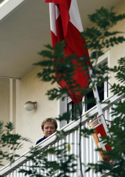 An unidentified personnel looks from the balcony of the Swiss Embassy in Athens after a bomb alert November 2, 2010. A bomb went off on Tuesday at the Swiss embassy in Athens but there were no immediate reports of injuries, Greek police officials said. [China Daily/Agencies] 