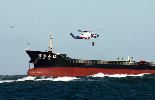 Crew members are lifted to safety by a helicopter, about 300 meters from the mouth of Shuangdao Bay in Weihai, East China&apos;s Shandong province, Nov 2, 2010. [Xinhua]