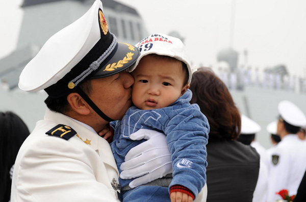 A Chinese navy officer kisses his son in Zhoushan, East China&apos;s Zhejiang province, before leaving for escort missions in the Gulf of Aden and Somali waters, Nov 2, 2010. [Xinhua]