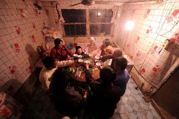Dong Zhijun (C) and his fiancé Yuan Wanyu (C) have supper with Zhijun&apos;s relatives in Tai&apos;an, northeast China&apos;s Liaoning Province, Oct. 25, 2010. [Xinhua]