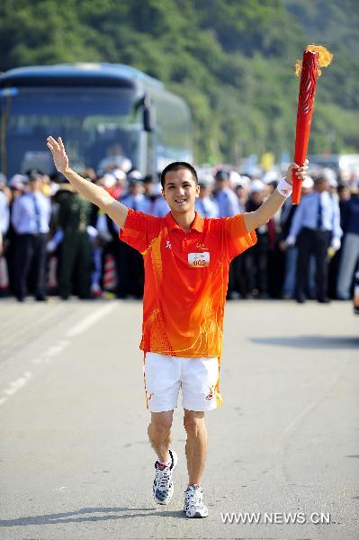 The 9th torchbearer Cen Yingfa runs with the torch during the torch relay for the 16th Asian Games in Yangjiang, south China's Guangdong Province, Nov. 2, 2010. (Xinhua/Liang Xu)