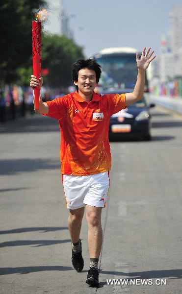 The 54th torchbearer Jin Li runs with the torch during the torch relay for the 16th Asian Games in Yangjiang, south China's Guangdong Province, Nov. 2, 2010. (Xinhua/Liang Xu)