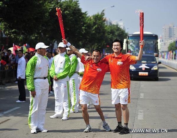 Torchbearers Xie Zhaoxing (2nd R) and Jin Li pose with the torches during the torch relay for the 16th Asian Games in Yangjiang, south China's Guangdong Province, Nov. 2, 2010. (Xinhua/Liang Xu)