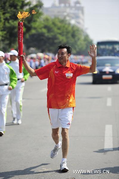 The 25th torchbearer Liang Yong runs with the torch during the torch relay for the 16th Asian Games in Yangjiang, south China's Guangdong Province, Nov. 2, 2010. (Xinhua/Liang Xu)