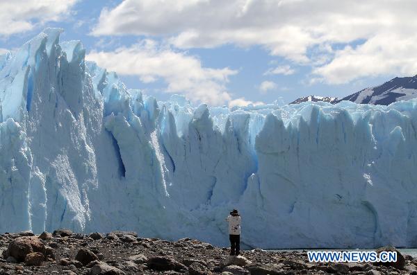 A tourist takes a photograph of the Perito Moreno Glacier, the most famous and stunning at Glacier National Park, opposite the Magallanes Peninsula, 78 kilometers away from the city of El Calafate, Argentina, on Nov. 2, 2010.