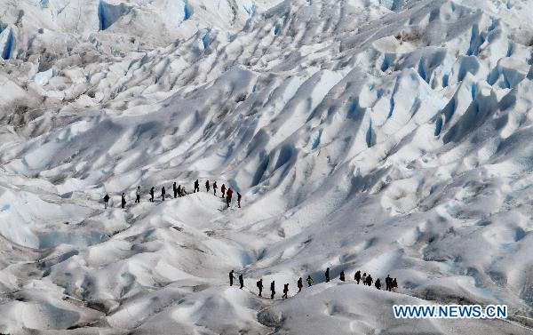 A tourist takes a photograph of the Perito Moreno Glacier, the most famous and stunning at Glacier National Park, opposite the Magallanes Peninsula, 78 kilometers away from the city of El Calafate, Argentina, on Nov. 2, 2010.