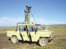 Yang Weikang looking for the houbara bustard atop a jeep at the Mori study area. 