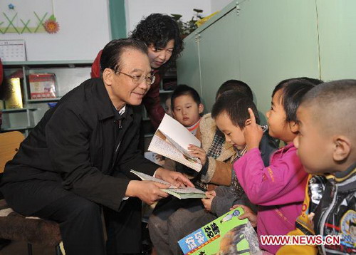 Chinese Premier Wen Jiabao (L) chats with children at Xiliushujing Kindergarten during an inspection over pre-school education in the downtown area of Beijng, capital of China, Nov. 2, 2010.[Photo/Xinhua]