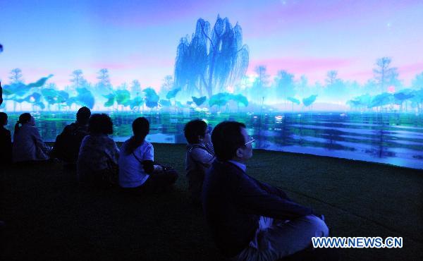 Visitors visit the circular theatre at the Pavilion of Dreams of 2010 Taipei International Flora Expo in Taipei, south China&apos;s Taiwan, Nov. 3, 2010. With the use of advanced sensor technology, the mechanical flowers at the Pavilion of Dreams vary in shape and color with the music and light, showing visitors a dreamlike world. [Xinhua] 