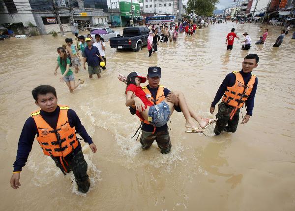 A soldier carries a woman injured during a flood in Hat Yai district, Songkhla province south of Bangkok November 3, 2010. Transport and communications were severed and tourists stranded on Wednesday after southern Thailand&apos;s worst floods in a decade forced flight cancellations and left a bustling city in deep water. [Xinhua/Reuters]