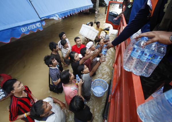 Residents receive water during a flood in Hat Yai district, Songkhla province south of Bangkok November 3, 2010. Transport and communications were severed and tourists stranded on Wednesday after southern Thailand&apos;s worst floods in a decade forced flight cancellations and left a bustling city in deep water. [Xinhua/Reuters]