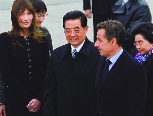 President Hu Jintao and his wife Liu Yongqing (right) are greeted by French President Nicolas Sarkozy and his wife Carla Bruni (left) upon arrival at Orly airport near Paris on Thursday at the start of a three-day visit, Nov 4, 2010. [China Daily/Agencies]