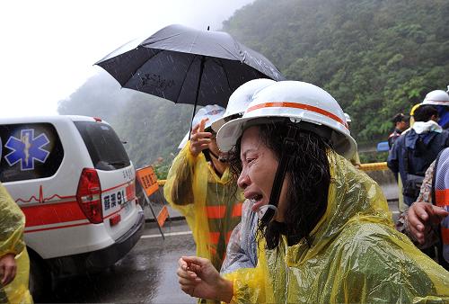 Relatives of the missing tourists shed tears on Suao-Hualien Highway, south China&apos;s Taiwan, Nov. 4, 2010. Over 40 relative representatives came to the coastal Suao-Hualien Highway on Thursday to mourn for their family members who were confirmed dead or still missing after the typhoon-triggered landslides on Oct. 21. The disaster has left three dead including one mainland tourist Gong Yan, and 23 others missing, including 19 mainland tourists. [Xinhua]