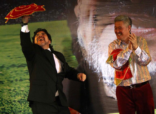 Maradona performs errenzhuan, a folksy two-person stand-up comedy form native to Northeast China, as well-known comedian Zhao Benshan applauds during a charity dinner in Beijing, Nov 4, 2010. [Xinhua]