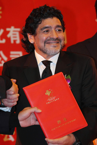 Maradona shows his letter of appointment awarded by the China Red Cross Foundation during a ceremony endorsing him as China&apos;s charity ambassador in Beijing, Nov 4, 2010. [Xinhua]