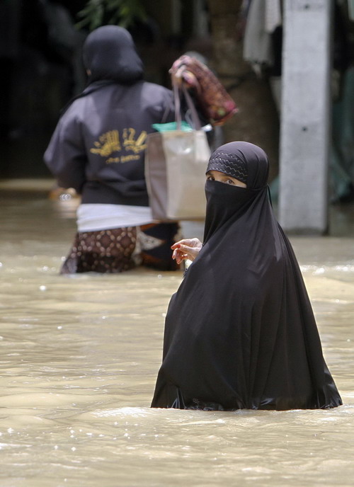 Thai Muslim women make their way through a flooded street in the southern Pattani province Nov 4, 2010. Floods that have killed at least 12 people in southern Thailand followed the worst flooding in decades in the northeast and centre of the country. In all, 122 people have died since early October.[China Daily/Agencies]