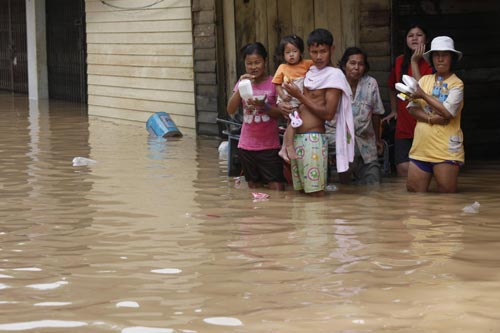 Residents stand in floodwaters in Hat Yai district, Songkhla province south of Bangkok November 3, 2010. [China Daily/Agencies]