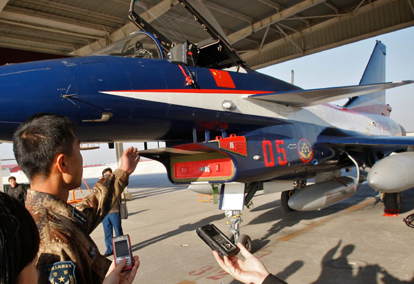 A PLA air force officer introduces the J-10 fighter jet of the August 1st Aerobatic Team to reporters at a military base in Tianjin on Tuesday. [Photo/China Daily] 