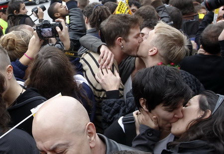 Homosexual couples kiss in the Plaza de la Catedral as the Pope travels in his Popemobile to the Sagrada Familia temple in Barcelona, November 7, 2010. They are protesting against Pope Benedict&apos;s visit to Spain. [China Daily/Agencies]