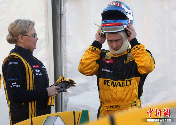 Russian Prime Minister Vladimir Putin receives instructions from officials from Renault as he prepares to drive a racing car at the race track outside St. Petersburg, Russia, Sunday, Nov. 7, 2010. Putin tested his capacities as a Formula One driver. [Chinanews.com.cn]