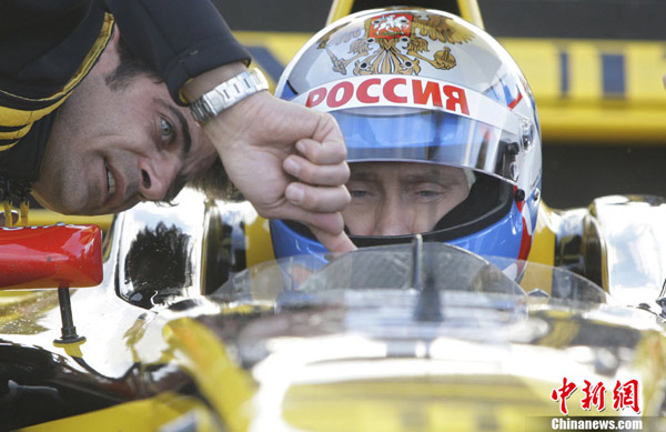 Russian Prime Minister Vladimir Putin receives instructions from officials from Renault as he prepares to drive a racing car at the race track outside St. Petersburg, Russia, Sunday, Nov. 7, 2010. Putin tested his capacities as a Formula One driver. [Chinanews.com.cn]