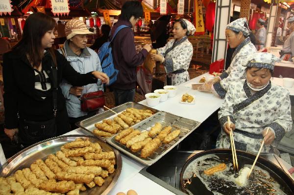 People buy snacks during the Macao Food Festival at a plaza in Macao, south China, Nov. 5, 2010. The 17-day Macao Food Festival kicked off on Friday. [Xinhua/Cheong Kam Ka]