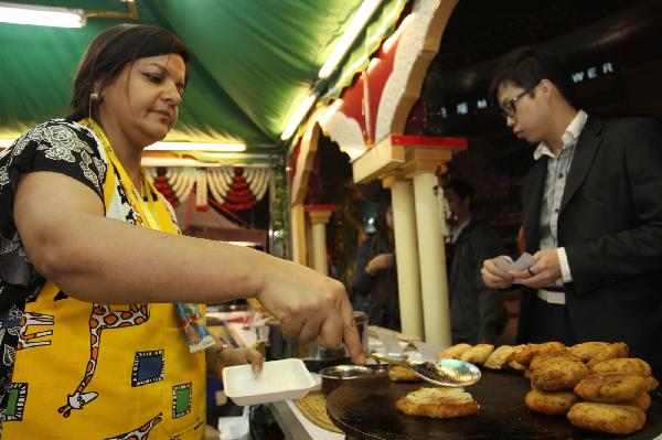 A cook makes snacks during the Macao Food Festival at a plaza in Macao, south China, Nov. 5, 2010. The 17-day Macao Food Festival kicked off on Friday. [Xinhua/Cheong Kam Ka]