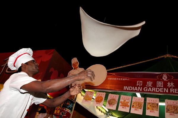 A chef makes roti prata during the Macao Food Festival at a plaza in Macao, south China, Nov. 5, 2010. The 17-day Macao Food Festival kicked off on Friday. [Xinhua/Cheong Kam Ka]