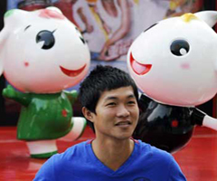 A visitor poses before the mascots of the 16th Asian Games in Guangzhou, the host city of the Games on November 7, 2010.