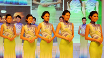 Hostesses model costume that will be worn for medal ceremonies at the 2010 Asian Games. The theme is 'Xingyun Liushui,' or 'Floating Clouds and Flowing Water'.