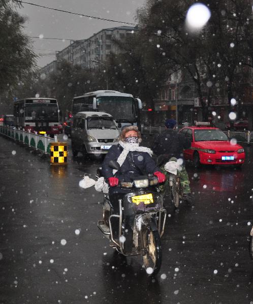 A citizen rides in the snow in Mudanjiang, northeast China&apos;s Heilongjiang Province, Nov. 7, 2010. A cold front was sweeping the northern parts of China, causing snowfall or sleet and making the temperature drop in the areas.