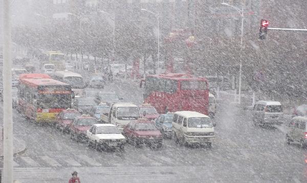 Vehicles are seen in the snow in Harbin, capital of northeast China&apos;s Heilongjiang Province, Nov. 7, 2010. A cold front was sweeping the northern parts of China, causing snowfall or sleet and making the temperature drop in the areas. 