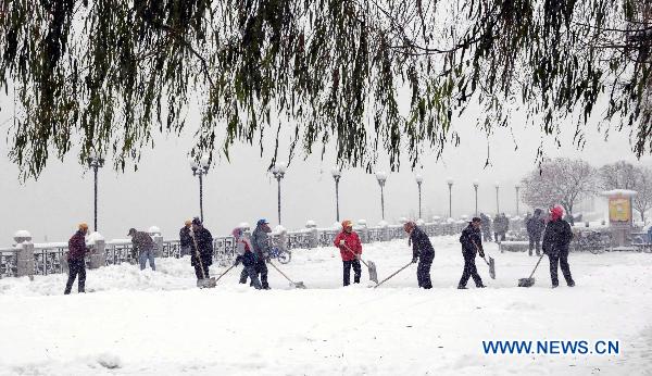 People clear snow on a street in Jilin City, northeast China&apos;s Jilin Province, Nov. 8, 2010. Snow hit most parts of Jilin province from Sunday, making the temperature fall by up to 10 degrees Celsius in some areas. 