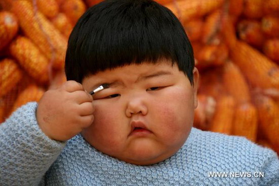 Fan Sijia brushes her eyebrow at home in Dongniu Village of Yuncheng City, north China's Shanxi Province, on Nov 4, 2010. [Photo/Xinhua] 