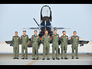 Team members of China's Bayi Aerobatic Team (L-R) Shan Wenping, Guo Fuyong, Li Bin, Cao Zhen, Wei Guoyi, Jiang Jinquan, Cao Zhenzhong pose for a photo in front of a J-10 jet fighter with new coating in Tianjin, east China, Nov. 5, 2010. [Xinhua]